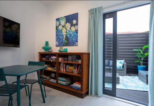 a dining room with a table and a book shelf at Riverstone Retreat Upper Hutt in Upper Hutt