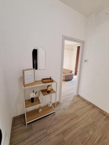 a room with a white wall and a mirror at La casa del viaggiatore in Trino