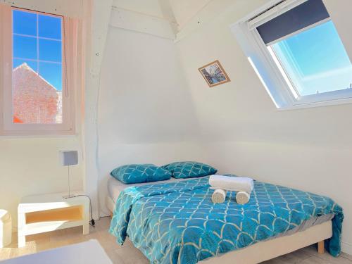 une chambre avec un lit avec des draps bleus et une fenêtre dans l'établissement CHARME VIEUX LILLE Apartment 1 chambre 24H24H Access, à Lille
