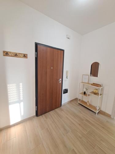 an empty room with a wooden door and a shelf at La casa del viaggiatore in Trino