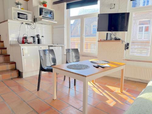 une cuisine avec une table et des chaises dans une pièce dans l'établissement CHARME VIEUX LILLE Apartment 1 chambre 24H24H Access, à Lille