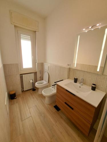 a bathroom with a sink and a toilet and a mirror at La casa del viaggiatore in Trino