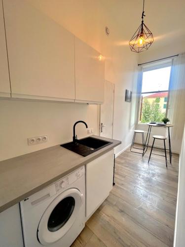 une cuisine avec un évier et une machine à laver dans l'établissement Festival Park Luxe Studio, à Menton