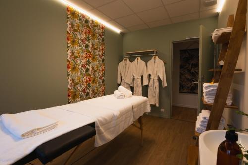 a hospital room with a bed and clothes at The Originals City, Ara Hôtel, Landerneau in Landerneau