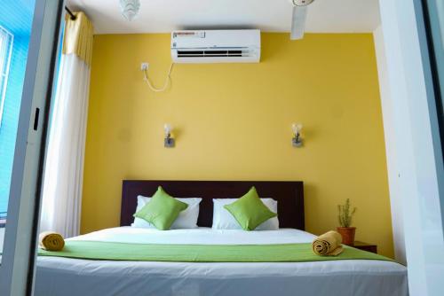 a bedroom with a bed with a yellow wall at Rosemary Villa - Welegoda, Matara in Matara