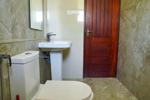 a bathroom with a toilet and a sink and a door at Rosemary Villa - Welegoda, Matara in Matara