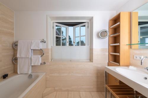 a bathroom with a tub and a sink and a window at Benen-Diken-Hof in Keitum