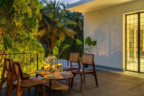 a patio with a table and chairs and a fence at Minimalist Panjim in Panaji