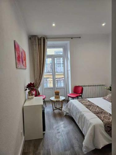 a bedroom with a bed and a red chair and a window at Casalondres emTR77 in Lisbon