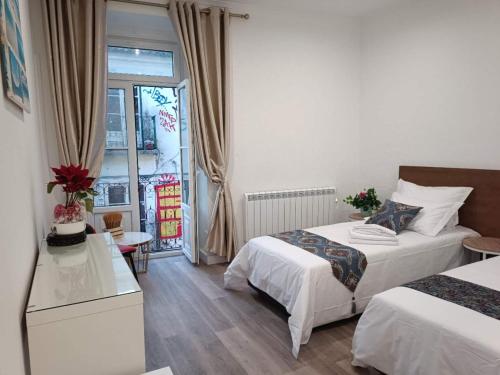 a hotel room with two beds and a window at Casalondres emTR77 in Lisbon