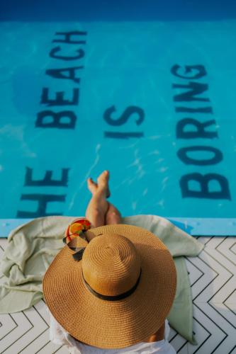 a baby wearing a straw hat next to a swimming pool at Minimalist Panjim in Panaji