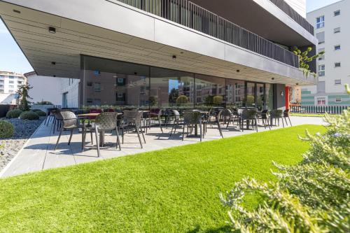 a patio with chairs and tables in front of a building at ICON H Lugano - Luxury Suites & Apartments in Lugano