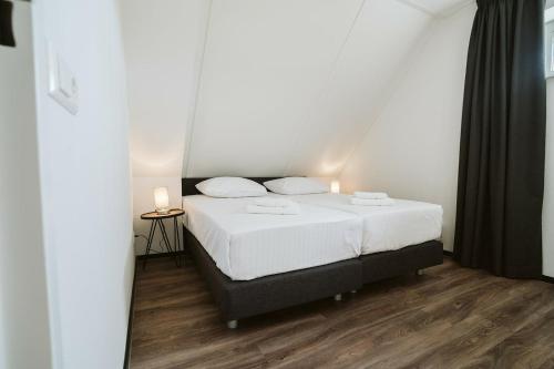 Un dormitorio con una cama con dos velas encima. en Vakantiehuis 6 persoons luxe, en Ouddorp