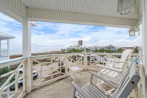 a porch with chairs and a view of the beach at Calypso Breeze in Gulf Shores