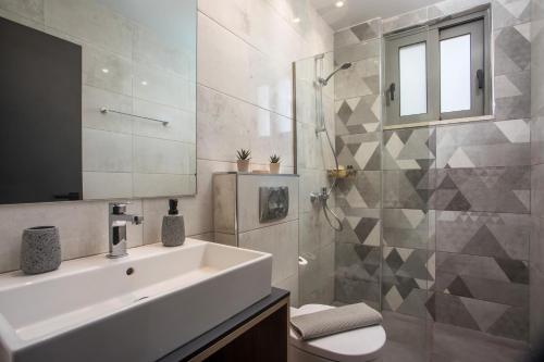 a bathroom with a sink and a toilet and a mirror at Ixia del sol Apartment in Ixia