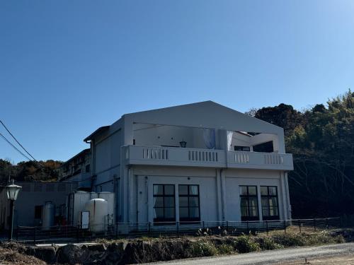 a large white building on the side of a road at 波のたわむれ in Kami Amakusa