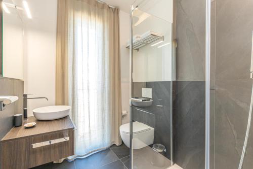 a bathroom with a toilet and a glass shower at ICON H Lugano - Luxury Suites & Apartments in Lugano