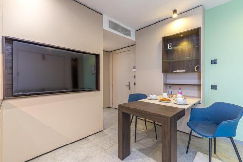a room with a table and two chairs and a flat screen tv at ICON H Lugano - Luxury Suites & Apartments in Lugano