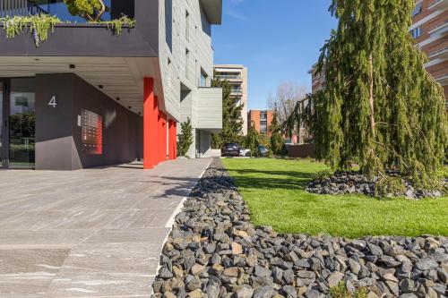 a sidewalk with rocks and a tree in front of a building at ICON H Lugano - Luxury Suites & Apartments in Lugano