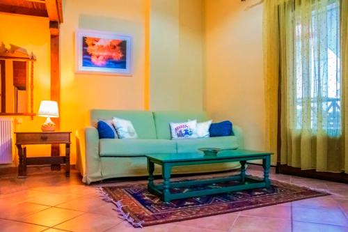 a living room with a green couch and a coffee table at Dallia Loft Space in Goumenissa