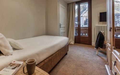 a hotel room with a bed and a window at Hôtel Lyret in Chamonix-Mont-Blanc