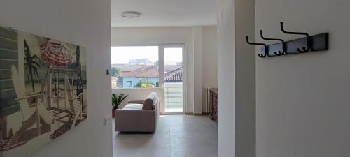a hallway with a living room with a chair and a window at Tominettihome in Verbania