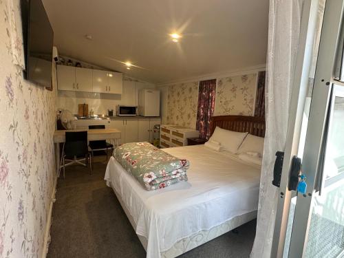 a small bedroom with a bed and a kitchen at Studio in Albert Town