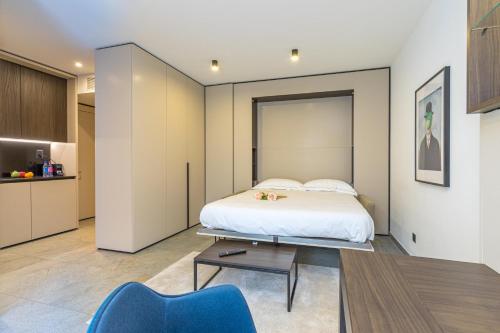 a bedroom with a bed and a blue chair at ICON H Lugano - Luxury Suites & Apartments in Lugano