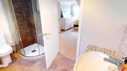 a bathroom with a shower and a toilet at Croyde Broadlands 5 Bedrooms in Croyde