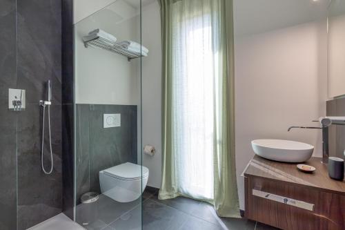 a bathroom with a shower and a toilet and a sink at ICON H Lugano - Luxury Suites & Apartments in Lugano