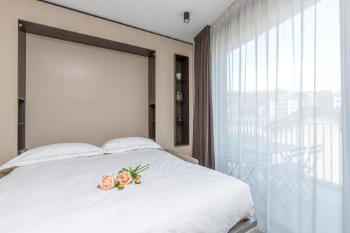 a bedroom with a white bed with flowers on it at ICON H Lugano - Luxury Suites & Apartments in Lugano