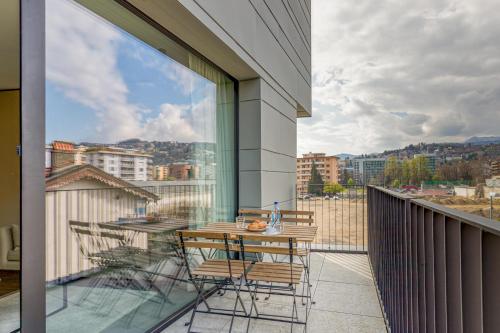a balcony with a table and chairs on a balcony at ICON H Lugano - Luxury Suites & Apartments in Lugano