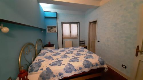 a bedroom with a bed with a blue wall at villamuna in Ferentillo