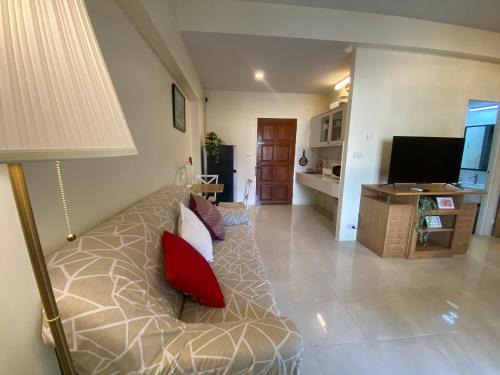 a living room with a couch and a television at Cozy 1br walk to BTS and Airport Rail Link Close to Malls m11 in Bangkok