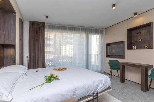 a bedroom with a large bed with a desk and a television at ICON H Lugano - Luxury Suites & Apartments in Lugano