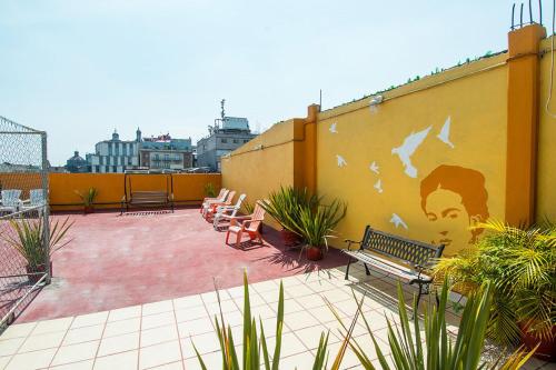 a patio with a mural of a man on a wall at Hotel Amigo Suites in Mexico City