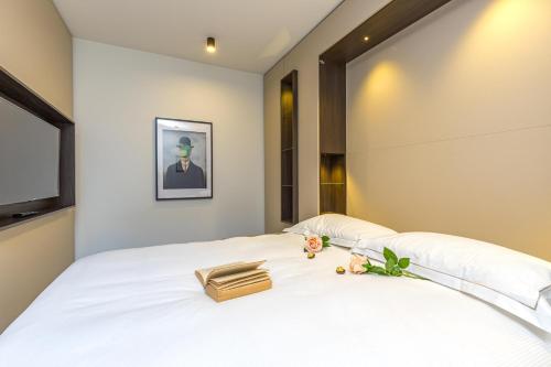 a bedroom with a white bed with a purse on it at ICON H Lugano - Luxury Suites & Apartments in Lugano