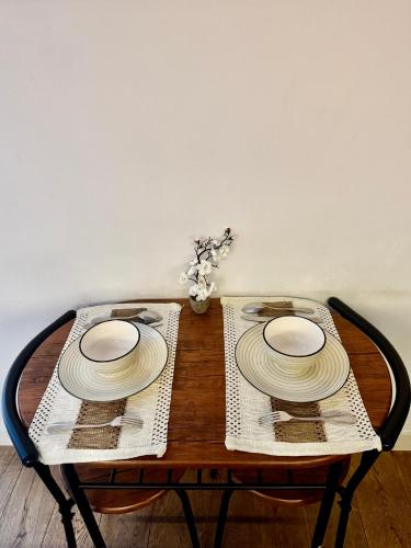 a wooden table with two plates on top of it at London City Island 1 Bedroom Luxury Apartments, Private Balcony in London