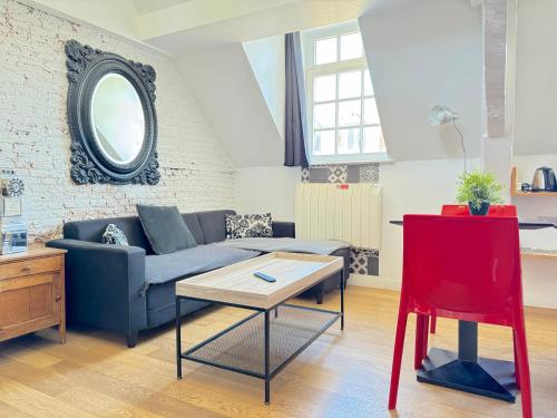 - un salon avec un canapé bleu et un fauteuil rouge dans l'établissement SOUVENIRS VIEUX LILLE Apartment 2 Chambres 24H24H Access, à Lille