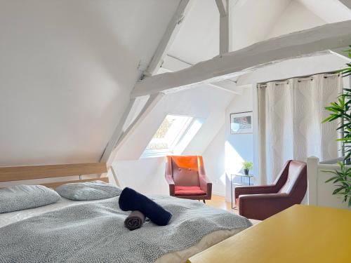 une chambre avec un lit et deux chaises dans l'établissement SOUVENIRS VIEUX LILLE Apartment 2 Chambres 24H24H Access, à Lille