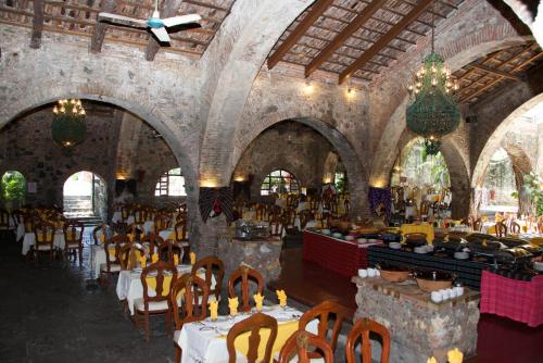 a dining room with tables and chairs in a building at Hotel Hacienda Vista Hermosa in Tequesquitengo