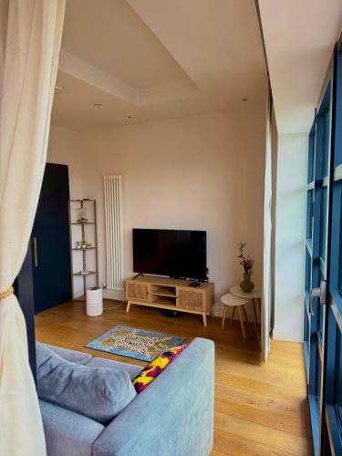 a living room with a couch and a flat screen tv at London City Island 1 Bedroom Luxury Apartments, Private Balcony in London