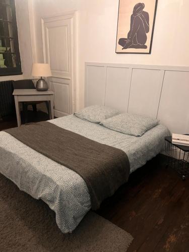 une chambre avec un lit avec une couverture grise dans l'établissement 2- Le chêne bleu, à Poitiers