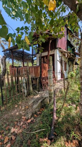 an old house with a fence in front of it at Three Little Birds in Tangalle