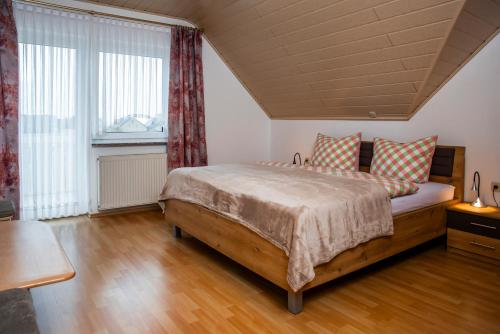 a bedroom with a bed and a large window at Ferienhaus Pauly in Bergen