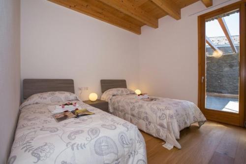 a bedroom with two beds and a window at house with 3 bedrooms T5 in Bellano