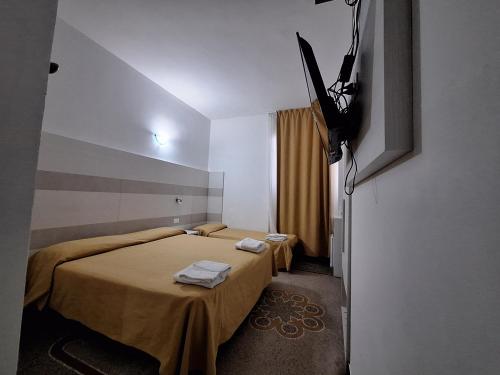 a hotel room with two beds and a television at Hotel Villa Costa in Celle Ligure