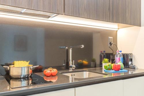 a kitchen counter with a sink and some tomatoes at ICON H Lugano - Luxury Suites & Apartments in Lugano