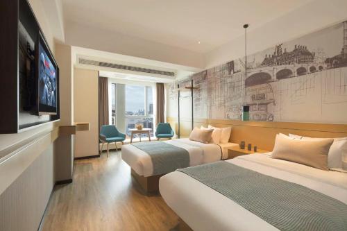 a hotel room with two beds and a flat screen tv at Chongqing North City Sky Hotel in Renhe