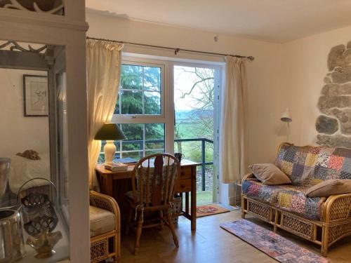 a living room with a table and a window at Oak Forest Cottage in Hacketstown
